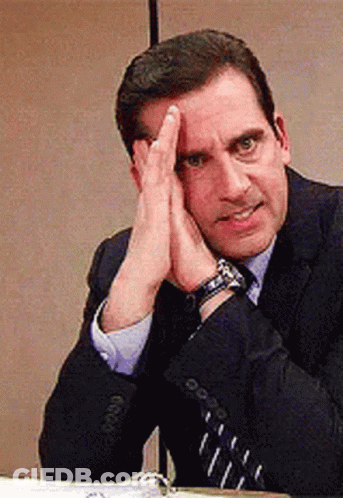 Man In Suit And Tie Sitting With Hands On Head GIF