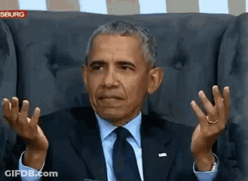 Man In Suit And Tie Sitting With Hands Up GIF