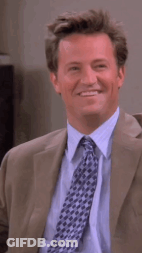 Man In Suit And Tie Smiling And Looking To Side GIF