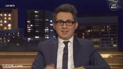 Man In Suit And Tie Smiling And Waving GIF