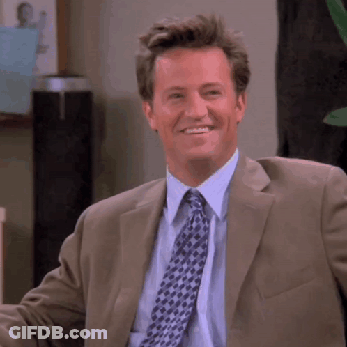 Man In Suit And Tie Smiling At Camera GIF