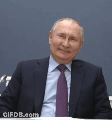 Man In Suit And Tie Smiling At Desk GIF