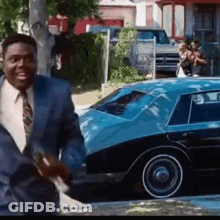 Man In Suit And Tie Smiling By Blue Car GIF