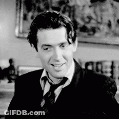 Man In Suit And Tie Smiling In Black And White GIF