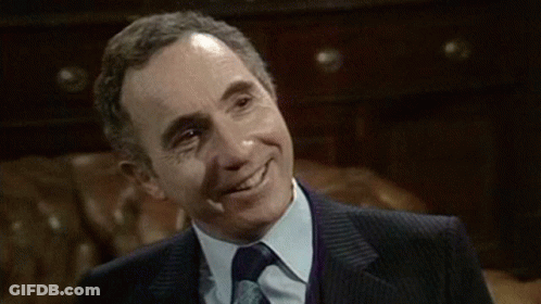 Man In Suit And Tie Smiling In Chair GIF