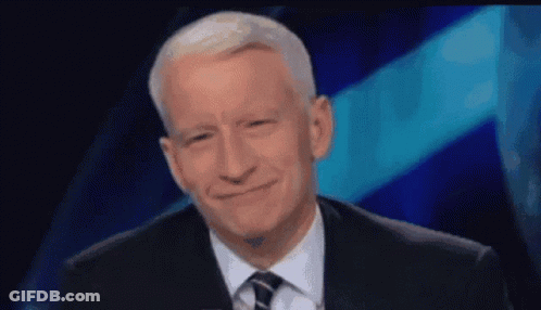 Man In Suit And Tie Smiling In Front Of Blue Background GIF