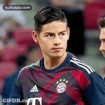 Man In Suit And Tie Smiling Next To Manchester United Shirt GIF