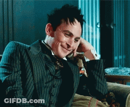 Man In Suit And Tie Smiling On Couch GIF