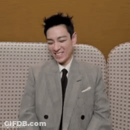 Man In Suit And Tie Smiling On Couch GIF
