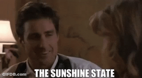 Man In Suit And Tie Smiling Talking To Woman The Sunshine State GIF