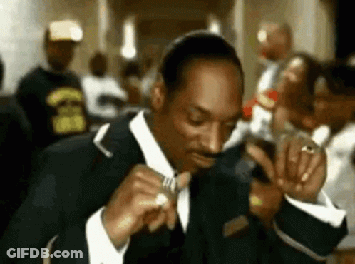 Man In Suit And Tie Smoking In Crowded Room GIF