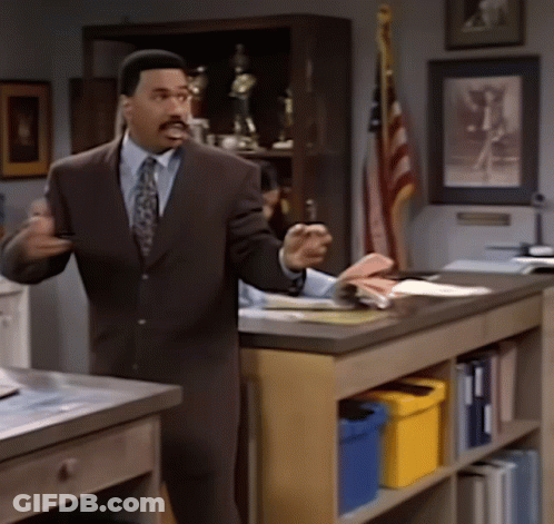 Man In Suit And Tie Standing At Counter GIF