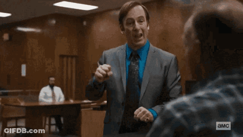 Man In Suit And Tie Standing Before American Flag GIF