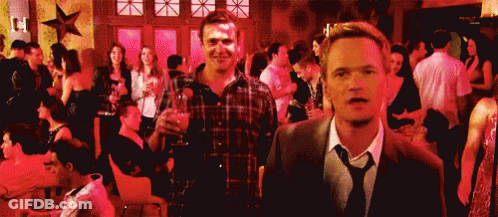 Man In Suit And Tie Standing Before Crowd At Party GIF
