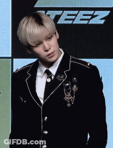 Man In Suit And Tie Standing Before Screen Saying Tbz GIF