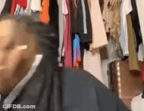 Man In Suit And Tie Standing By Closet GIF