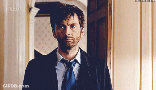 Man In Suit And Tie Standing By ITV Door GIF