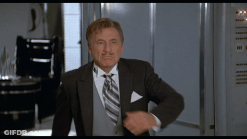 Man In Suit And Tie Standing By Locker GIF