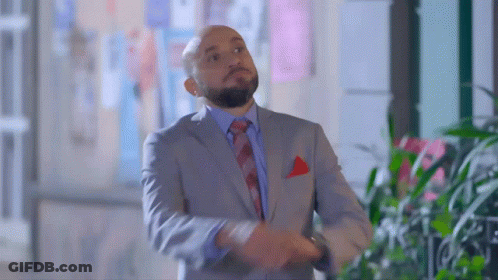Man In Suit And Tie Standing By Window GIF