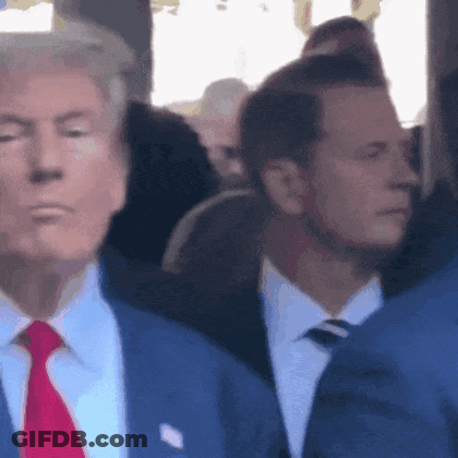 Man In Suit And Tie Standing In Crowd GIF