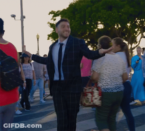 Man In Suit And Tie Standing In Crowd GIF