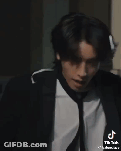 Man In Suit And Tie Standing In Dark Room GIF