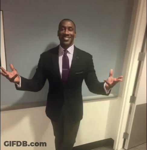 Man In Suit And Tie Standing In Doorway With Arms Outstretched GIF