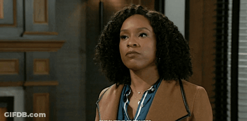 Man In Suit And Tie Standing In Front Of Bookshelf GIF