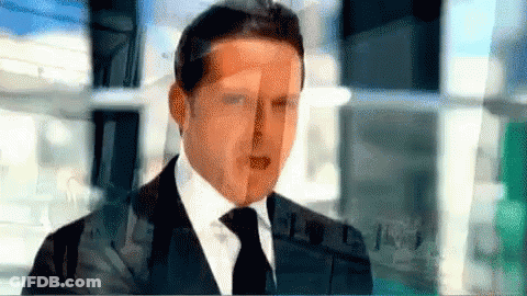 Man In Suit And Tie Standing In Front Of Building GIF