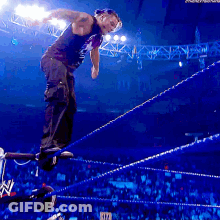 Man In Suit And Tie Standing In Front Of DJ Booth GIF