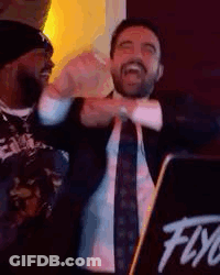 Man In Suit And Tie Standing In Front Of DJ Booth GIF