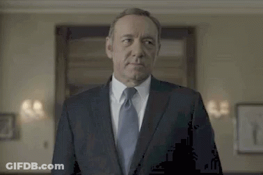 Man In Suit And Tie Standing In Front Of Door GIF
