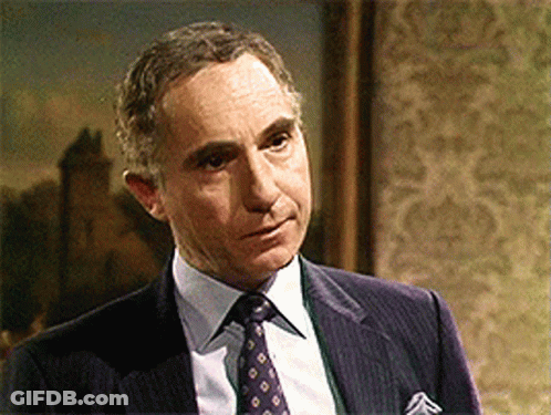 Man In Suit And Tie Standing In Front Of Framed Picture GIF