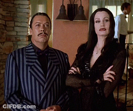 Man In Suit And Tie Standing In Front Of Hotel GIF