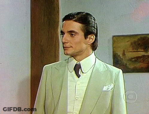 Man In Suit And Tie Standing In Front Of Picture GIF