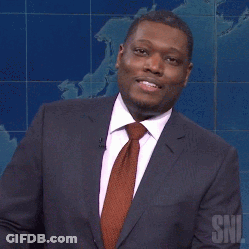 Man In Suit And Tie Standing In Front Of SNL Sign GIF