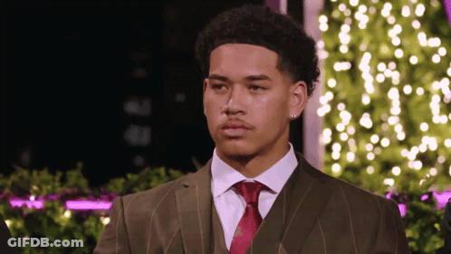 Man In Suit And Tie Standing In Front Of Tree GIF
