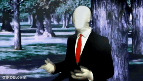 Man In Suit And Tie Standing In Front Of Trees GIF