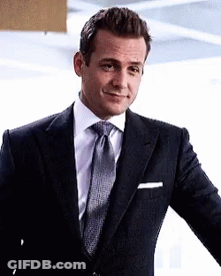 Man In Suit And Tie Standing In Front Of Wall GIF