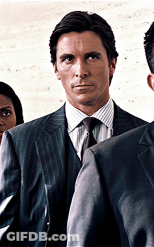 Man In Suit And Tie Standing In Front Of Woman GIF