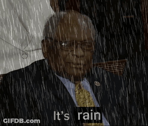 Man In Suit And Tie Standing In Rain Saying It's Raining GIF