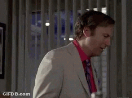 Man In Suit And Tie Standing In Room GIF