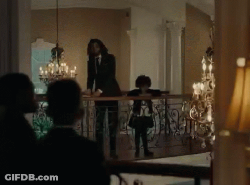 Man In Suit And Tie Standing On Balcony With Girl GIF