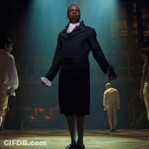 Man In Suit And Tie Standing On Stage GIF