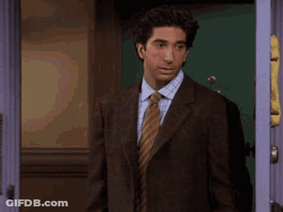Man In Suit And Tie Standing With Arms Out GIF