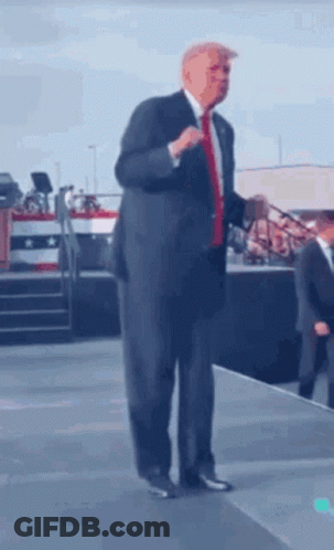 Man In Suit And Tie Talking On Stage GIF