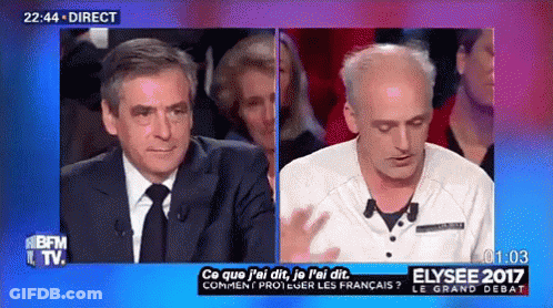 Man In Suit And Tie Talking To Another Man On TV Show GIF