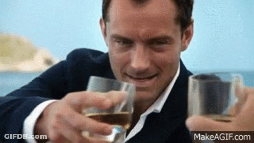 Man In Suit And Tie Toasting With Two Glasses Of Wine GIF
