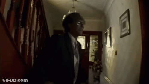 Man In Suit And Tie Walking Down Hallway GIF