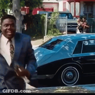 Man In Suit And Tie Walking In Front Of Blue Car GIF